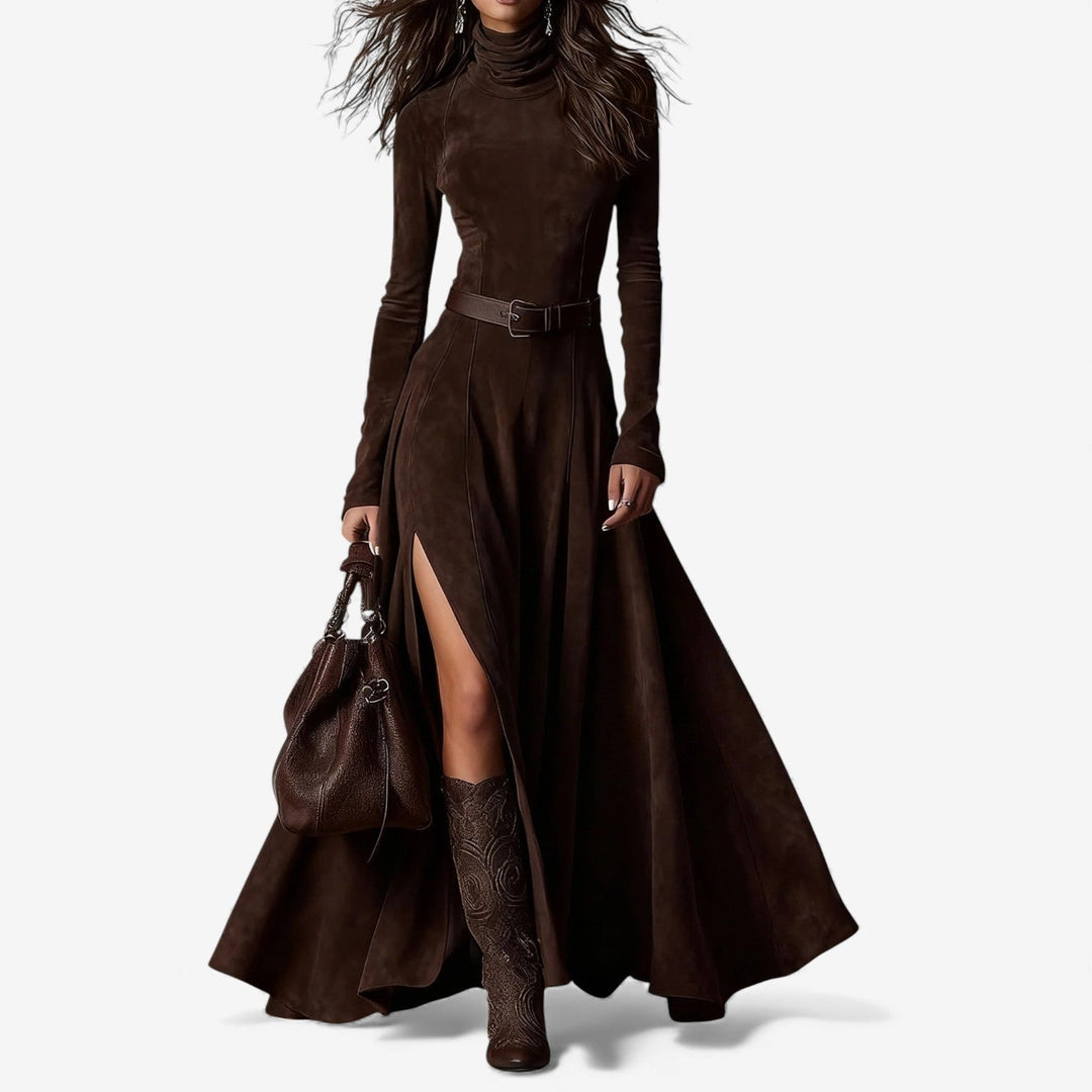 Woman wearing a long fluid maxi dress with a high neckline and a belt defining her waist.