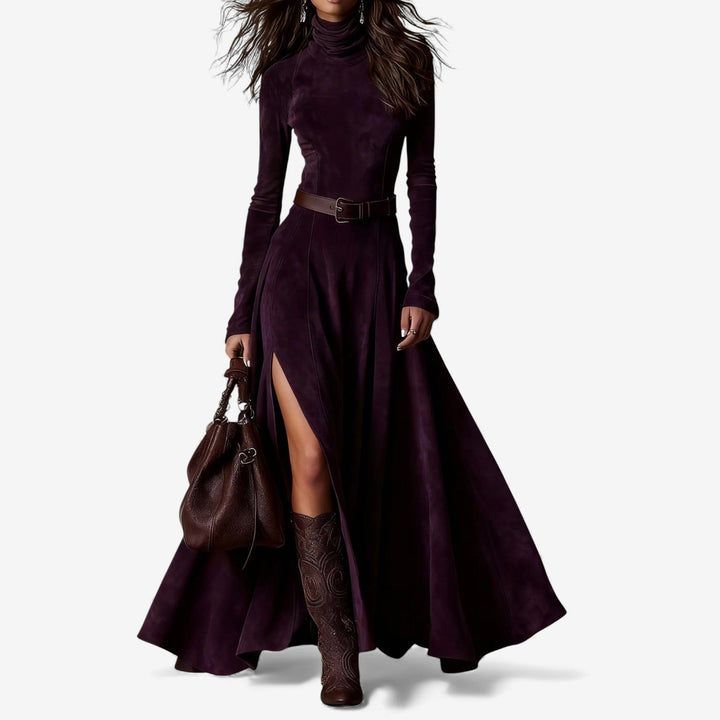 Woman wearing a long fluid maxi dress with a high neckline and a belt defining her waist.