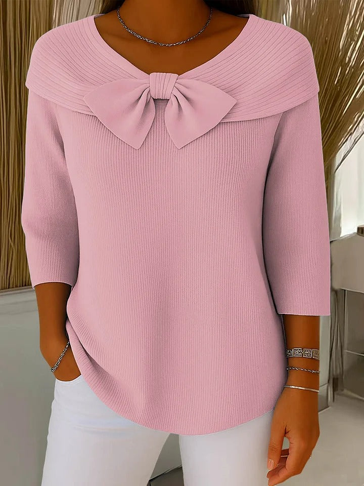 A woman wearing a shaped jumper with a soft bow detail, styled for a coffee date.