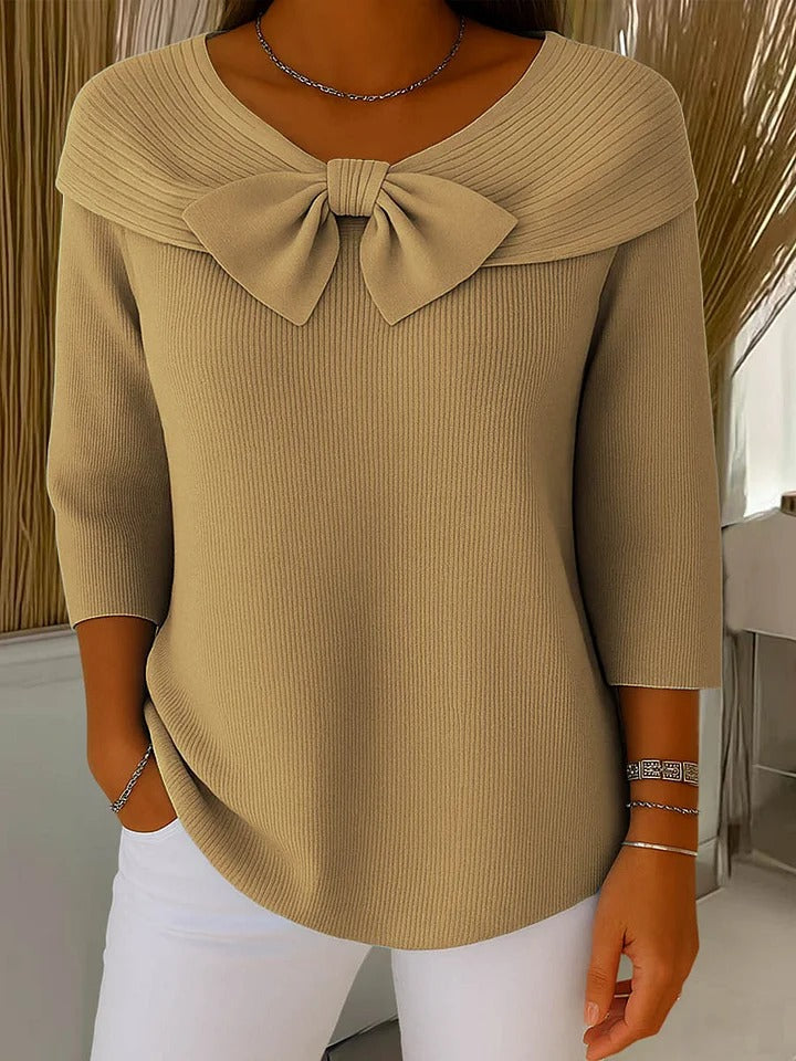 A woman wearing a shaped jumper with a soft bow detail, styled for a coffee date.