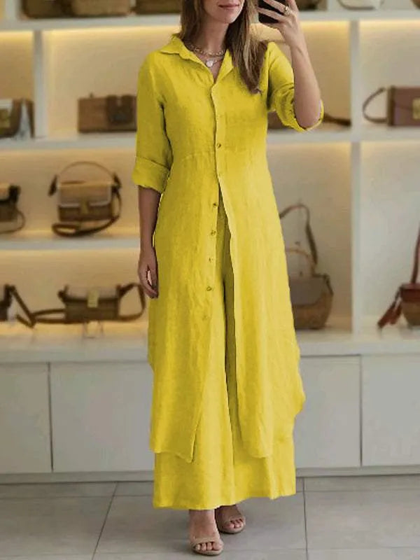 A woman wearing an elegant dress layered with flowing wide-leg trousers.