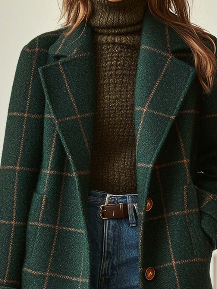 A woman wearing a classic checked belted coat in dark green with a defined waist.