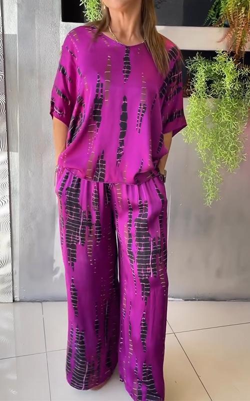 A woman wearing a vivid printed matching top and trousers set.