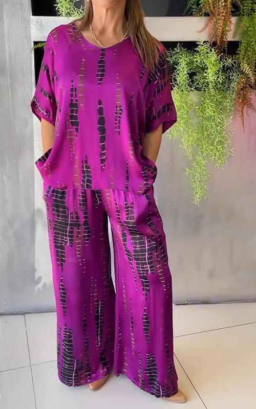 A woman wearing a vivid printed matching top and trousers set.
