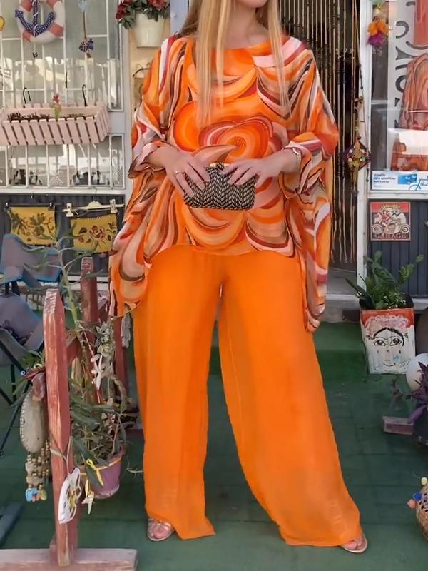 A woman wearing a swirl-print top with flowing wide-leg trousers