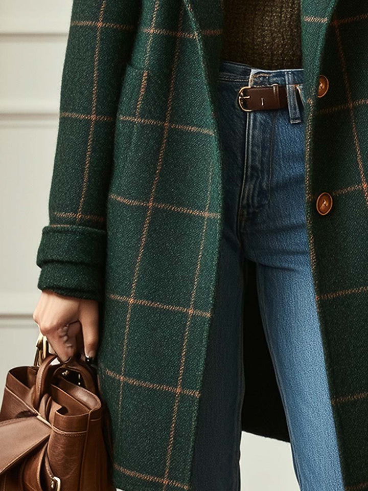 A woman wearing a classic checked belted coat in dark green with a defined waist.