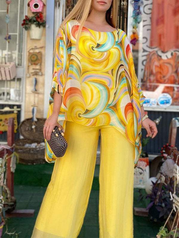 A woman wearing a swirl-print top with flowing wide-leg trousers