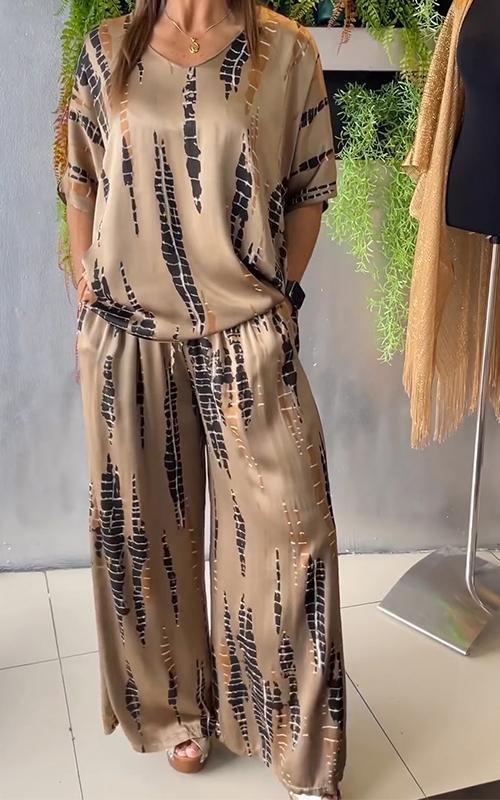 A woman wearing a vivid printed matching top and trousers set.