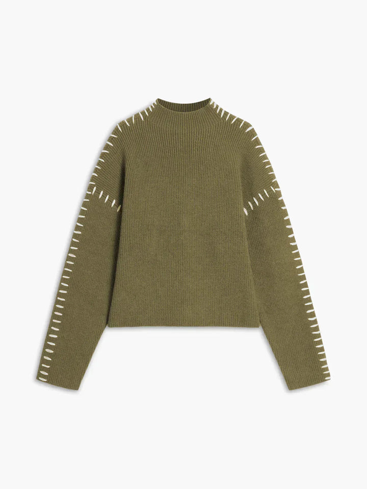 A woman wearing an oversized mock-neck jumper with whipstitch detailing, cosy and stylish.
