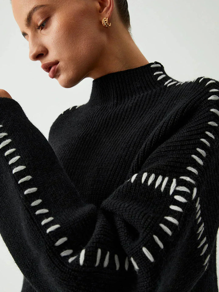 A woman wearing an oversized mock-neck jumper with whipstitch detailing, cosy and stylish.
