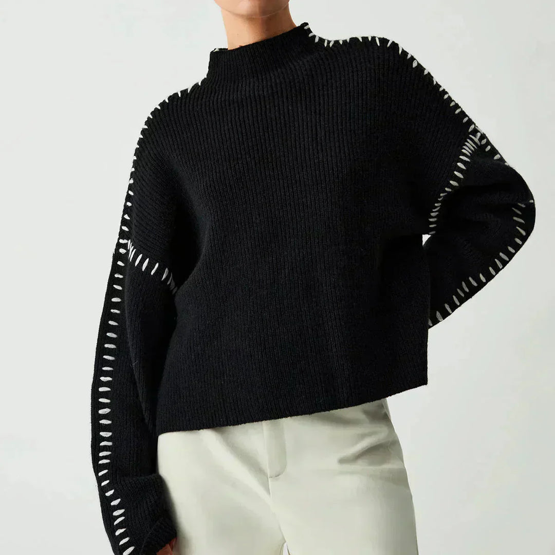 A woman wearing an oversized mock-neck jumper with whipstitch detailing, cosy and stylish.