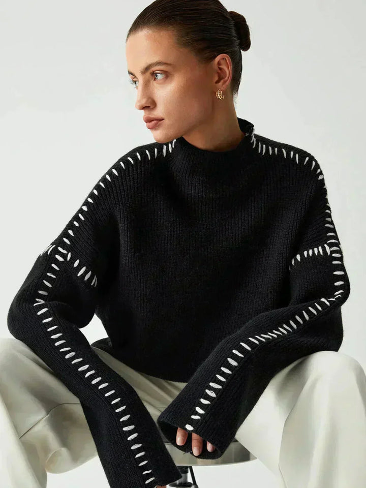 A woman wearing an oversized mock-neck jumper with whipstitch detailing, cosy and stylish.