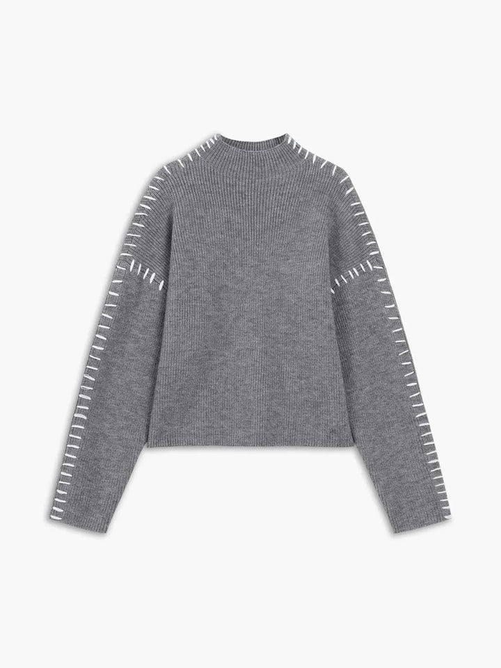 A woman wearing an oversized mock-neck jumper with whipstitch detailing, cosy and stylish.