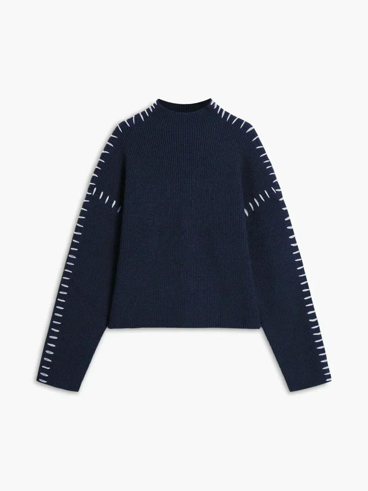 A woman wearing an oversized mock-neck jumper with whipstitch detailing, cosy and stylish.