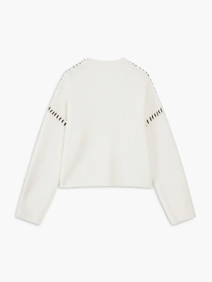 A woman wearing an oversized mock-neck jumper with whipstitch detailing, cosy and stylish.