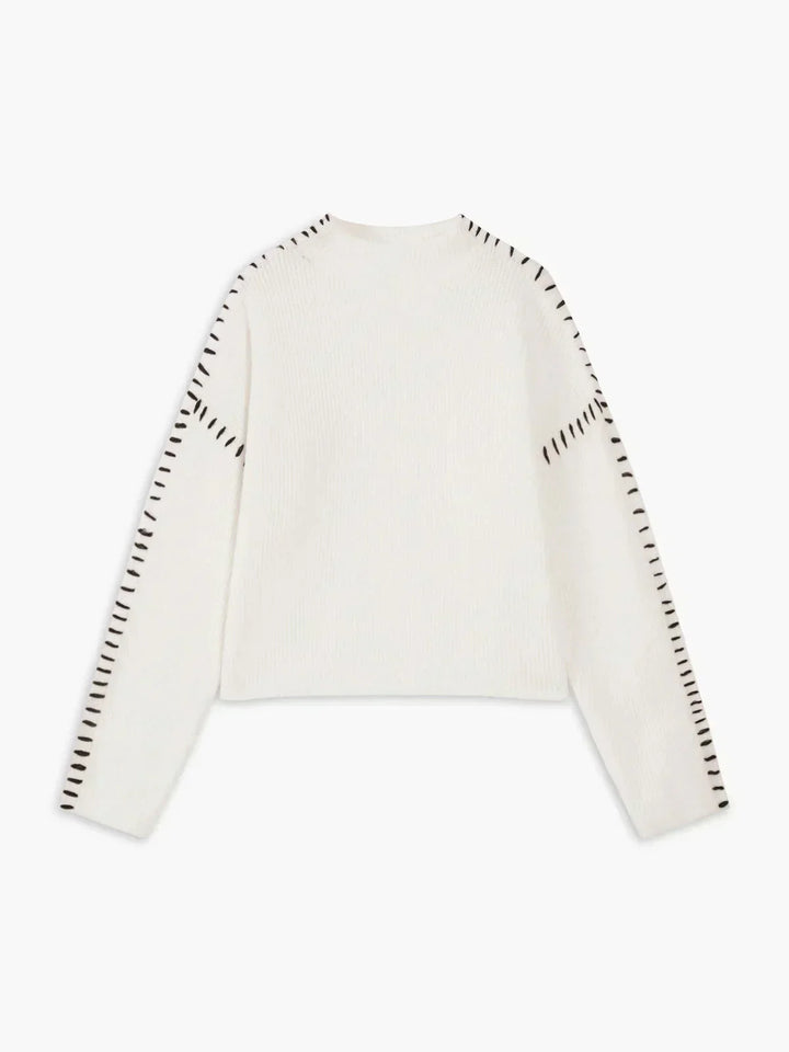 A woman wearing an oversized mock-neck jumper with whipstitch detailing, cosy and stylish.