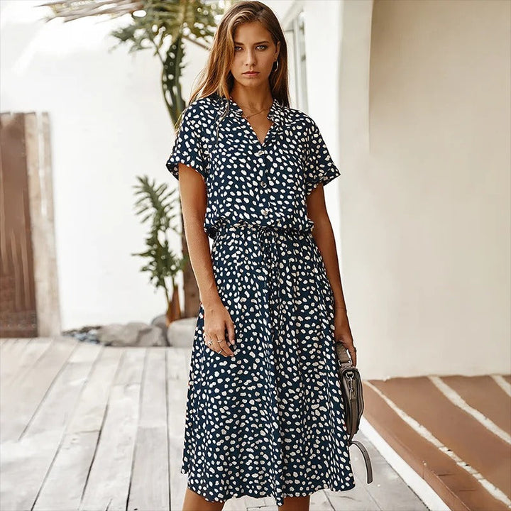 Woman wearing the Ursula™ printed summer midi dress with a flowing skirt, out for a bright summer stroll.