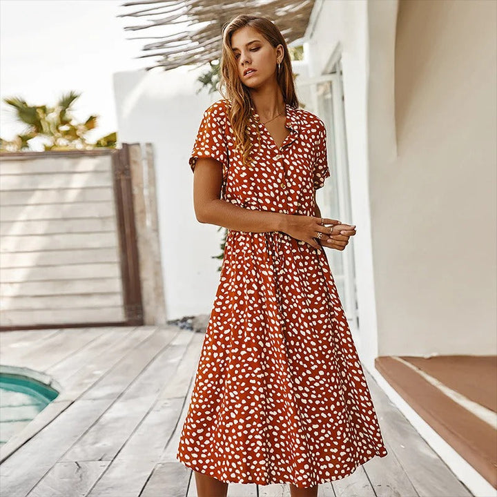 Woman wearing the Ursula™ printed summer midi dress with a flowing skirt, out for a bright summer stroll.