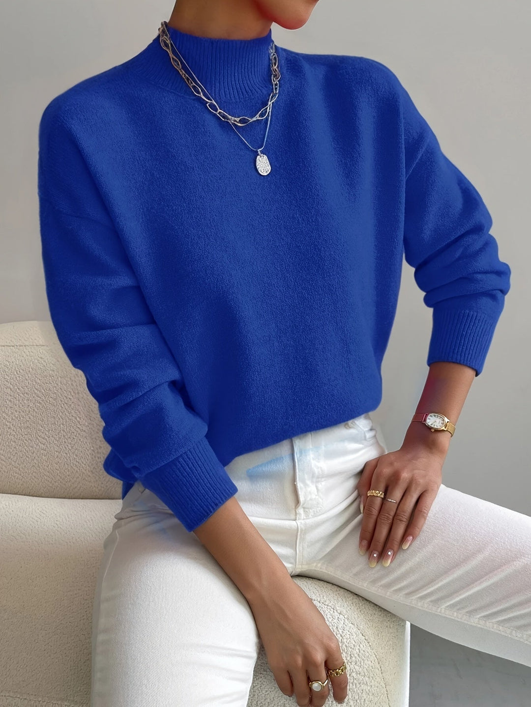 A woman wearing an elegant warm jumper with a modern stand collar, soft and refined.