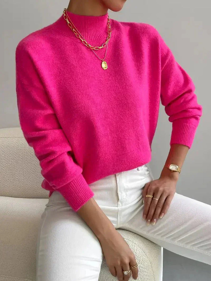A woman wearing an elegant warm jumper with a modern stand collar, soft and refined.