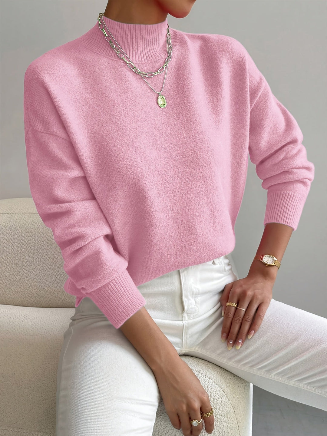 A woman wearing an elegant warm jumper with a modern stand collar, soft and refined.