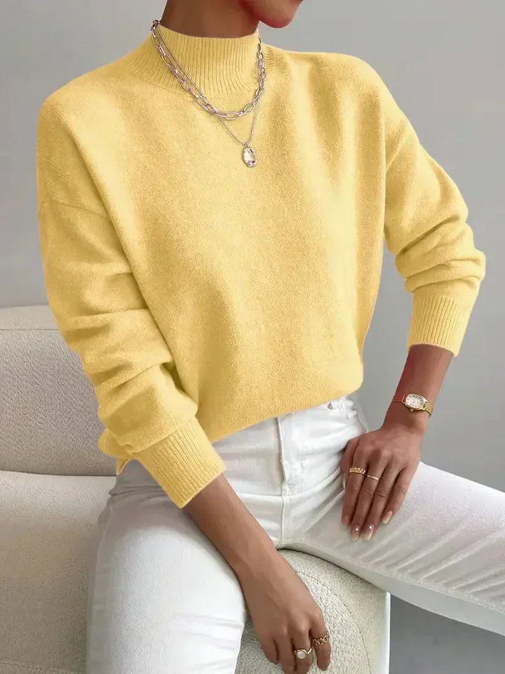 A woman wearing an elegant warm jumper with a modern stand collar, soft and refined.