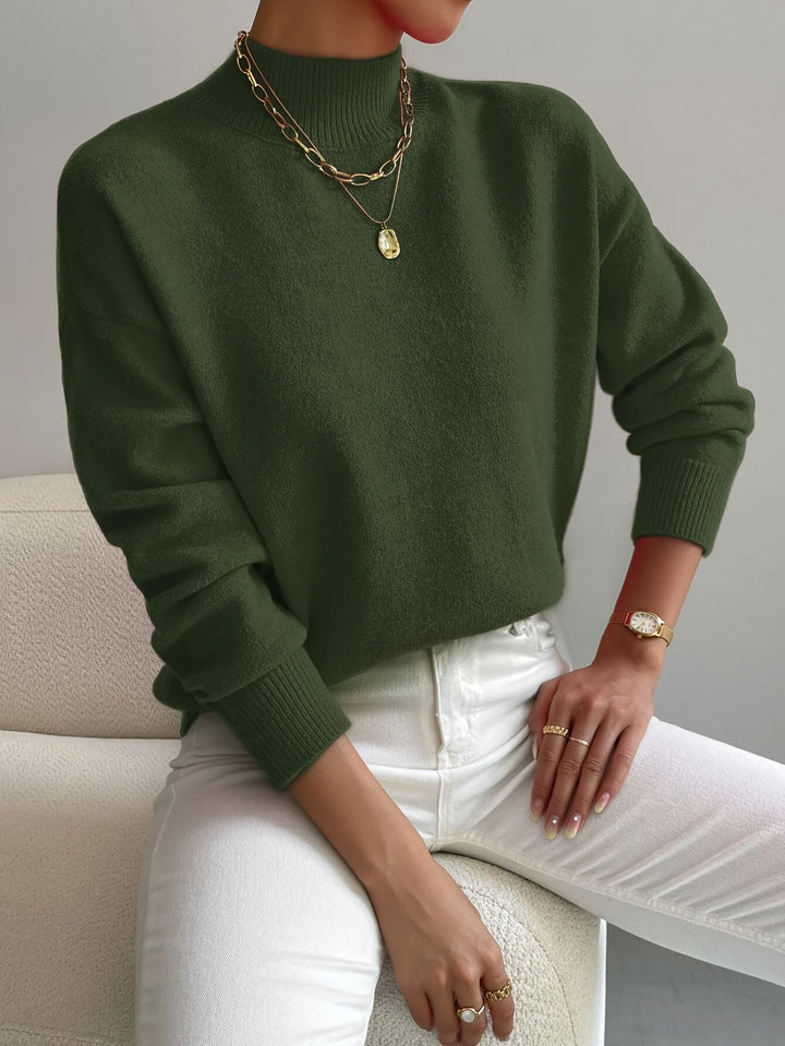 A woman wearing an elegant warm jumper with a modern stand collar, soft and refined.