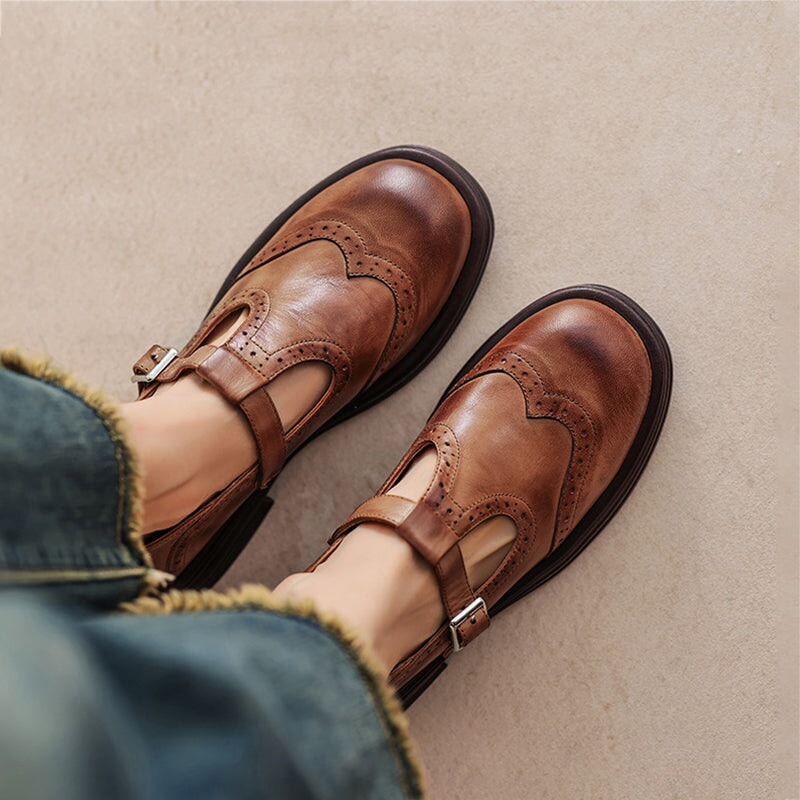 Brown and black Mary Jane shoes with brogue perforations and a T-bar strap