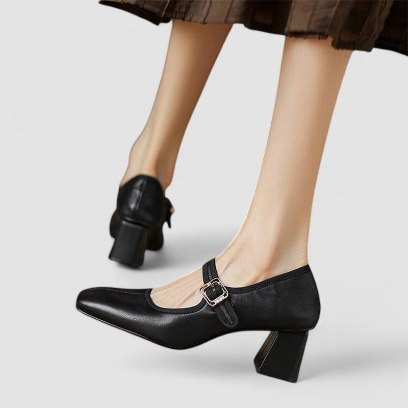 A woman in black Mary Jane shoes with a mid block heel, confident on an evening out.