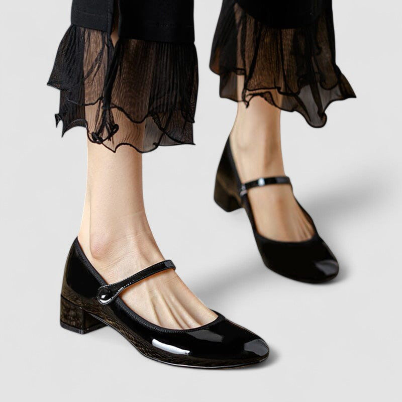 A woman wearing glossy black Mary Jane shoes with a low block heel, comfortable and steady during a day of errands.
