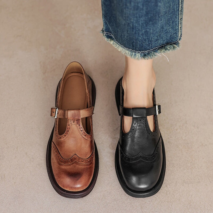 Brown and black Mary Jane shoes with brogue perforations and a T-bar strap