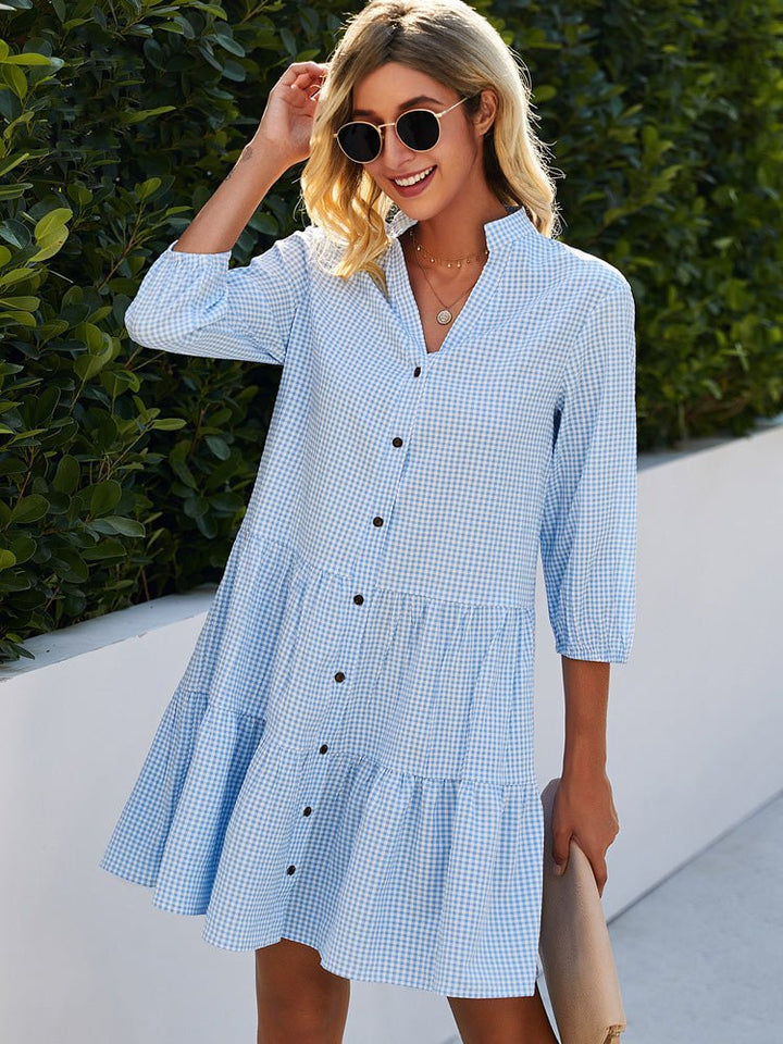 Woman wearing the Ellen check-print day dress in blue, enjoying a morning walk.