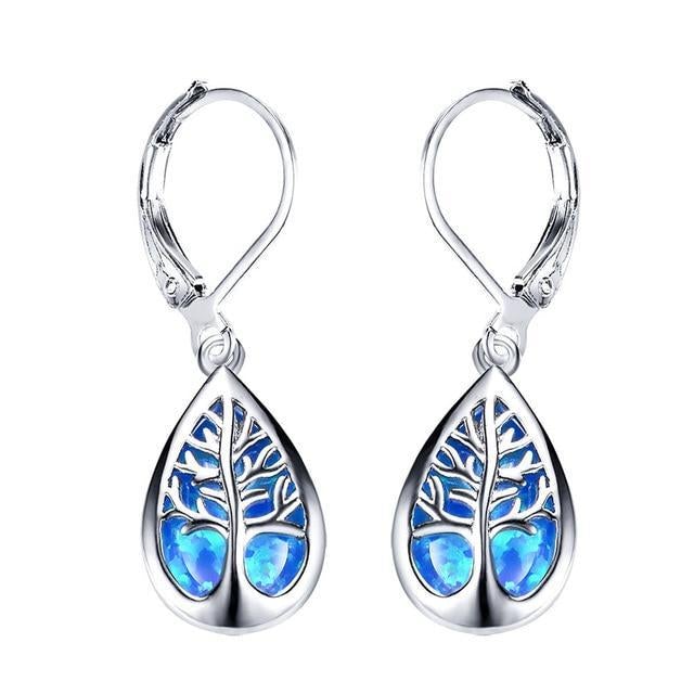 A pair of delicate drop earrings featuring a tree of life motif in blue and green tones