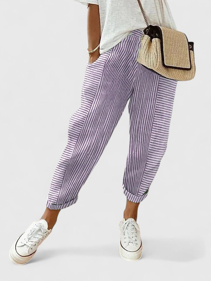 A woman wearing airy comfy summer trousers with an elastic waist and side pockets.