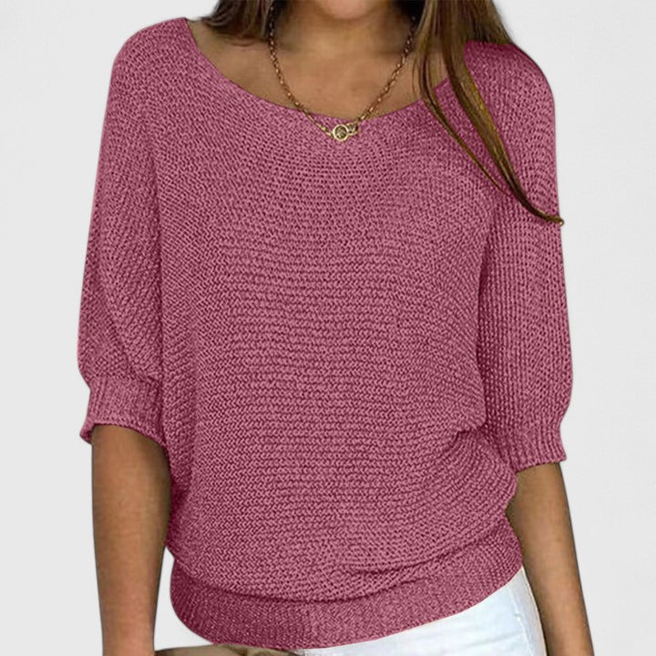 A woman wearing a soft purple jumper with a wide neckline and gently shaped fit.
