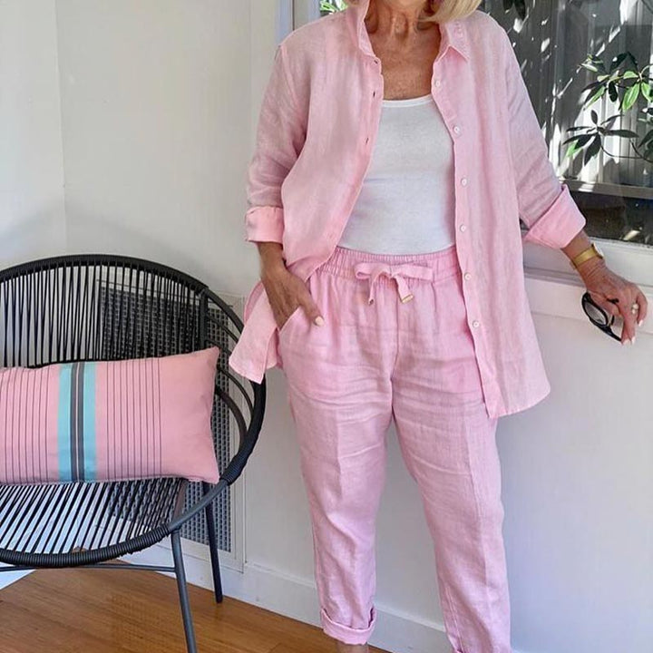 A woman wearing a light button-up shirt with matching drawstring lounge trousers.
