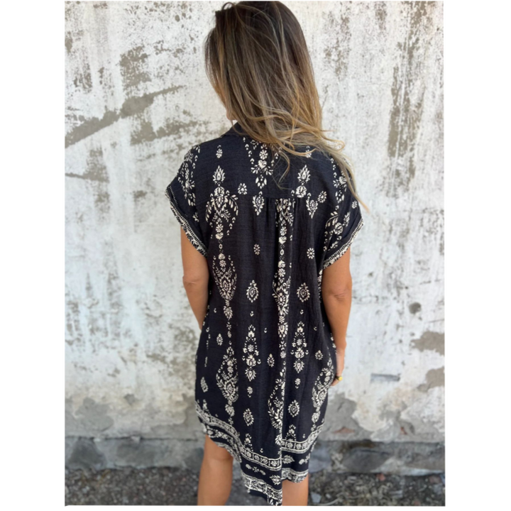 Woman wearing the Edith vintage print shirt dress with a button front and soft collar, standing in warm daylight.