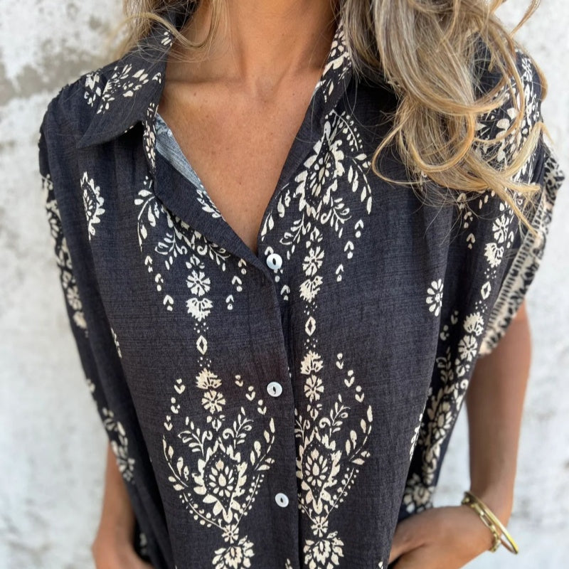 Woman wearing the Edith vintage print shirt dress with a button front and soft collar, standing in warm daylight.