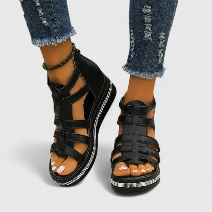 A woman in black strappy sandals walking confidently on a summer day, feet relaxed and supported.