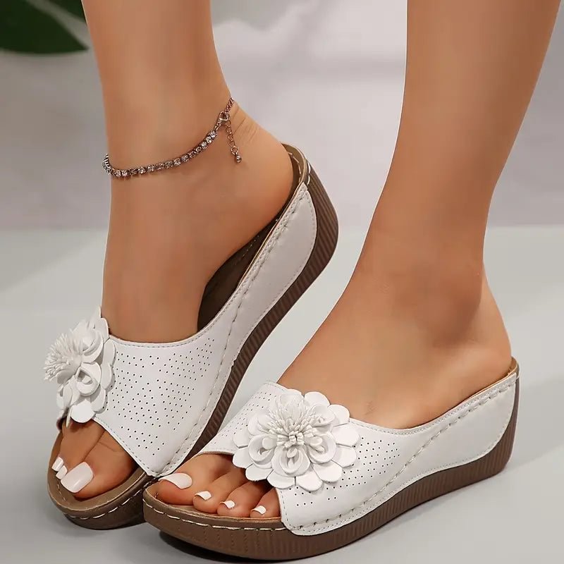 Beige wedge sandals with a delicate floral detail on the strap