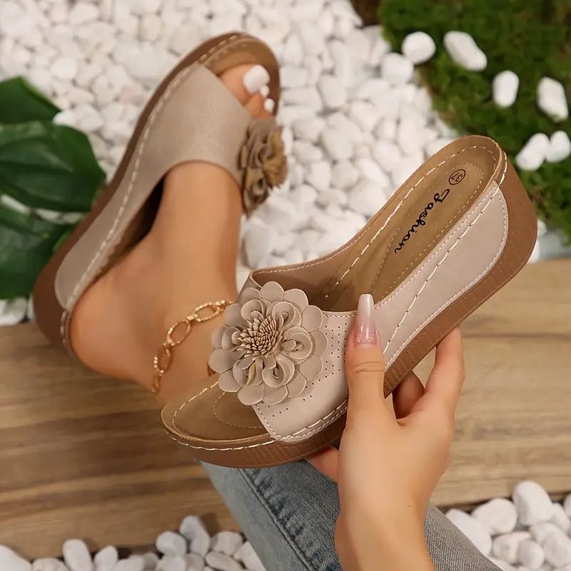 Beige wedge sandals with a delicate floral detail on the strap