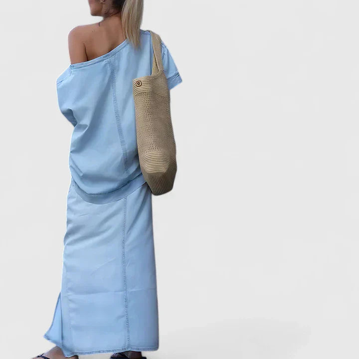 A woman in an asymmetric two-piece skirt set with a front slit, styled for an elegant occasion.