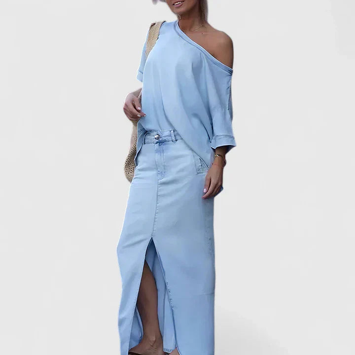 A woman in an asymmetric two-piece skirt set with a front slit, styled for an elegant occasion.
