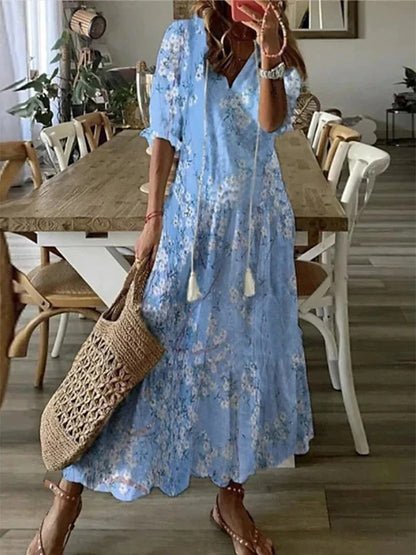 A woman wearing the Fiona boho midi dress with tassel ties at the neckline and a ruffled skirt.