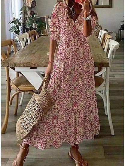 A woman wearing the Fiona boho midi dress with tassel ties at the neckline and a ruffled skirt.
