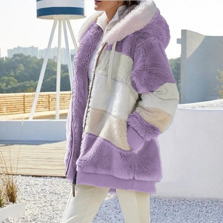 A woman wearing a hooded jacket with side pockets on a cold, rainy day out.