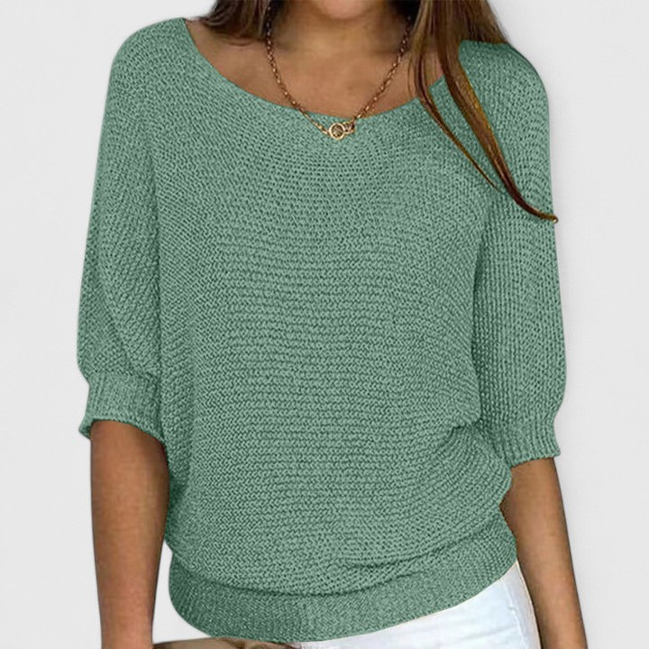 A woman wearing a soft purple jumper with a wide neckline and gently shaped fit.