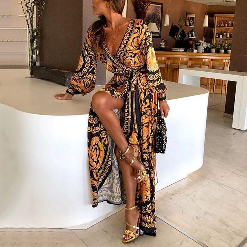Woman at golden hour wearing the Tessa vintage print maxi dress with a waist belt and long statement sleeves.