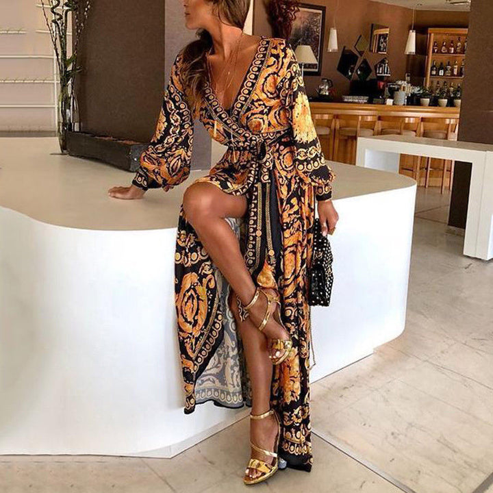 Woman at golden hour wearing the Tessa vintage print maxi dress with a waist belt and long statement sleeves.