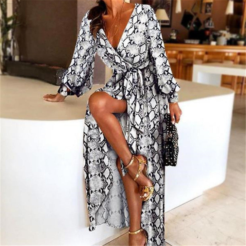 Woman at golden hour wearing the Tessa vintage print maxi dress with a waist belt and long statement sleeves.